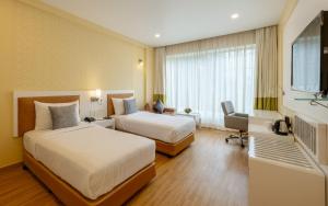 孟买Hotel Kohinoor Elite near BKC的酒店客房配有两张床和一张书桌