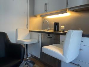 奥斯陆Oslo apartment center的厨房配有水槽和带两个凳子的台面