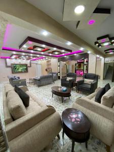 瓦迪穆萨Petra Guests Hotel的客厅配有沙发、桌子和紫色灯