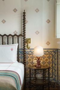 梅利迪什Vermelho Melides的一间卧室配有一张床和一张带台灯的桌子