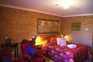 阿米代尔白灯笼汽车旅馆的一间卧室设有一张床和砖墙
