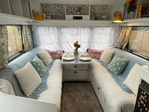 霍利韦尔Top Pen Y Parc Farm Glamping的带沙发和拖车桌子的房间