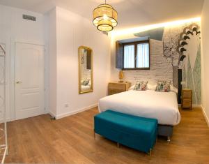 托莱多GALIANA CERVANTES 5 COLLECTION的卧室配有一张白色大床和蓝色凳子