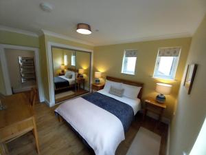卡伦德Stunning Village Centre Holiday Home的一间卧室配有一张大床和镜子