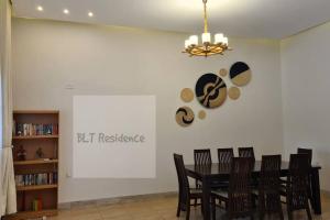 卡塞斯BLT Residence - Kasese A serene and tranquil home的一间用餐室,配有黑色的桌子和椅子