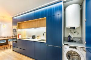 布拉加Sé Apartamentos - Dom Miguel Apartment的厨房配有蓝色橱柜和洗衣机。