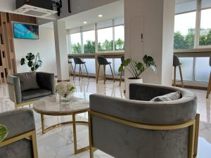 曼谷Golden Nest Hotel Suvarnabhumi的客厅配有两把椅子和一张桌子
