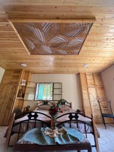 阿杰隆Oak Farm مزرعة الملّول的一间卧室设有一张床和木制天花板