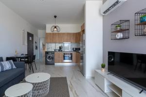 拉纳卡Yasou 1- Bedroom Apartment in Larnaca的客厅以及带沙发和桌子的厨房。
