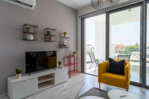 拉纳卡Yasou 1- Bedroom Apartment in Larnaca的客厅配有电视和黄色椅子