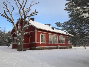 TöfsalaLittle Red School House的雪中红色的建筑,有树