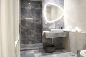 海若克利欧Eclectic Apartment near Downtown的浴室配有盥洗盆和带镜子的淋浴
