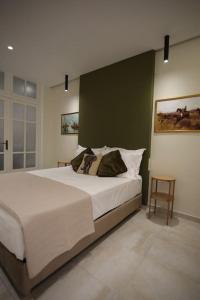 海若克利欧Eclectic Apartment near Downtown的一间卧室设有一张大床和绿色的墙壁