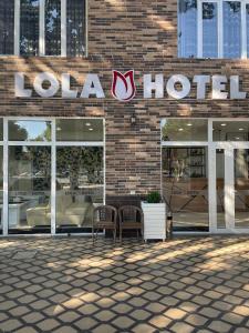 KokandLola Kokand Hotel的砖楼一侧的酒店标志