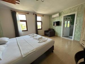 格克切达镇Akar Butik Otel的一间带白色床的卧室和一间浴室