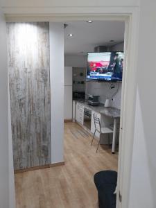 马德里Céntrico apartamento con patio的客厅配有书桌和墙上的电视