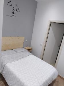 马德里Céntrico apartamento con patio的卧室配有白色的床,墙上有鸟儿