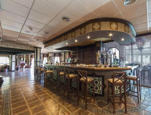 奥亨Hotel Wellness Marbella Hills的餐厅内的酒吧配有椅子和柜台