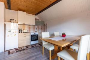博希尼Apartment and room Mateja Kovačič的厨房配有木桌和白色冰箱。