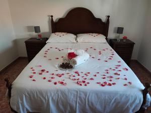 科武港Apartamentos Guiomar Campos的白色毯子上铺着红玫瑰的床