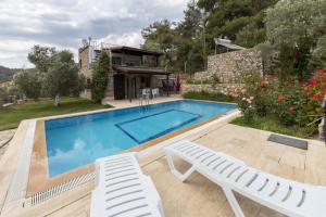 居吕克Refreshing Villa near Milas-Bodrum Airport的一个带两把白色椅子的游泳池