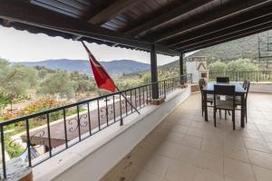 居吕克Refreshing Villa near Milas-Bodrum Airport的阳台配有桌椅和国旗。