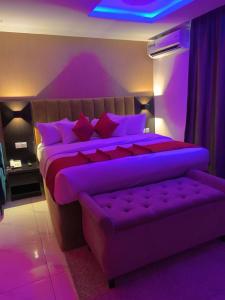 拉各斯NO 95 SUITES VI的紫色卧室,配有紫色照明床