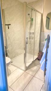 FewstonBramall House Accommodation的浴室里设有玻璃门淋浴