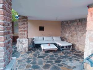 卡兰兹拉Garden House KRISTI的一个带沙发和桌子的庭院和砖墙