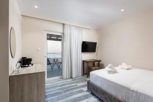 卡尔扎迈纳Kyma Rooms & Suites的酒店客房设有一张床,享有海景。