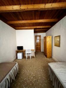 撒马尔罕卡文赛瑞酒店的一间卧室配有两张床和一张书桌。