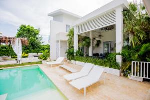 蓬塔卡纳Tranquil Lakefront 5-Bedroom Villa with Cook, Maid, Golf Cart, and Beach Access in Punta Cana的一座带游泳池和房子的别墅