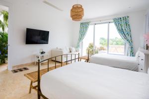 蓬塔卡纳Tranquil Lakefront 5-Bedroom Villa with Cook, Maid, Golf Cart, and Beach Access in Punta Cana的一间白色卧室,配有两张床和电视
