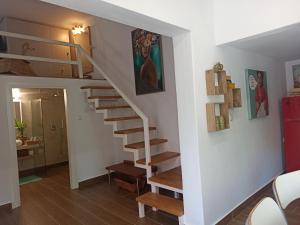 帕拉塔蒙Cosy loft的房屋内的楼梯,拥有白色的墙壁和木地板