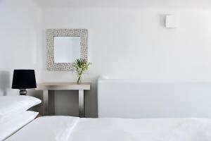 菲罗斯特法尼Belvedere Suites的一间卧室配有两张床和一张带镜子的桌子