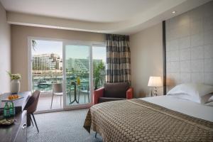 埃拉特埃拉特丹帕诺拉玛酒店的酒店客房设有一张床和一个阳台。
