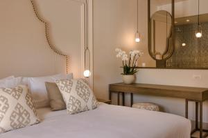 拉瑟Thalassa Boutique Hotel - Adults Only的一间卧室配有一张床和一张带镜子的桌子