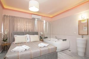 扎金索斯镇Ex Animo - Luxury Apartments的一间卧室配有一张床、一个浴缸和一个水槽