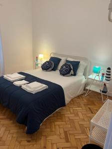 里斯本Alvalade II Airport Guest House的一间卧室配有一张大床,提供蓝色的床单和枕头