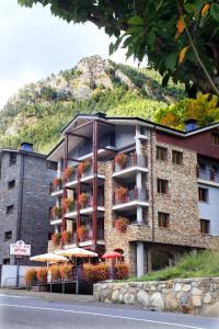 阿林萨尔Vista Arinsal Apartments的山前有雨伞的建筑