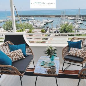 圣费利切-奇尔切奥AMAREA Exclusive Suites的一个带椅子和桌子的庭院,享有海港的景色