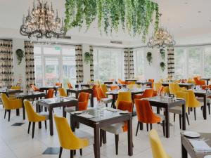 皇家滕布里奇韦尔斯SPA酒店的用餐室配有桌子和黄色椅子