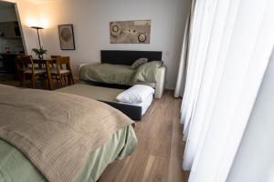 布宜诺斯艾利斯Barrancas Quality Apartments的一间卧室配有两张床和一张桌子及椅子