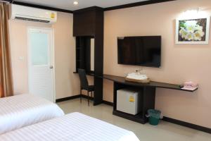 呵叻Triton Hotel Nakhonratchasima โรงแรมไททัน的酒店客房设有一张床和墙上的电视