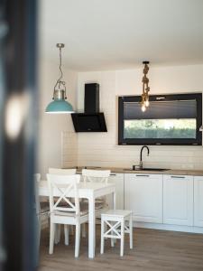 弗瓦迪斯瓦沃沃Domki Kapitalne的厨房配有白色的椅子、桌子和水槽
