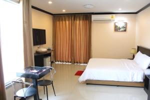 呵叻Triton Hotel Nakhonratchasima โรงแรมไททัน的一间卧室配有一张床、一张桌子和一张书桌