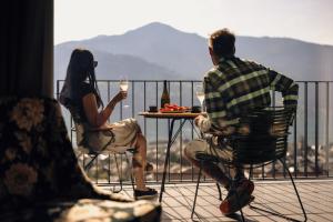 滨湖采尔Nikolaus by AvenidA Panoramic Wellness Suites的坐在桌子上戴酒杯的男人和女人