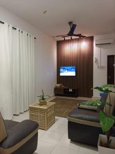 波德申Reco Villa Private Pool 4 Bedrooms@ Taman Mayung Teluk Kemang Port Dickson的带沙发和平面电视的客厅