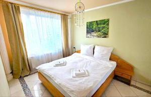 OslipDreamly Suites的一间卧室配有一张带白色床单的床和一扇窗户。