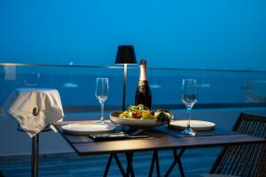 卡尔扎迈纳Kyma Rooms & Suites的一张桌子,上面放着一瓶香槟和一碗水果